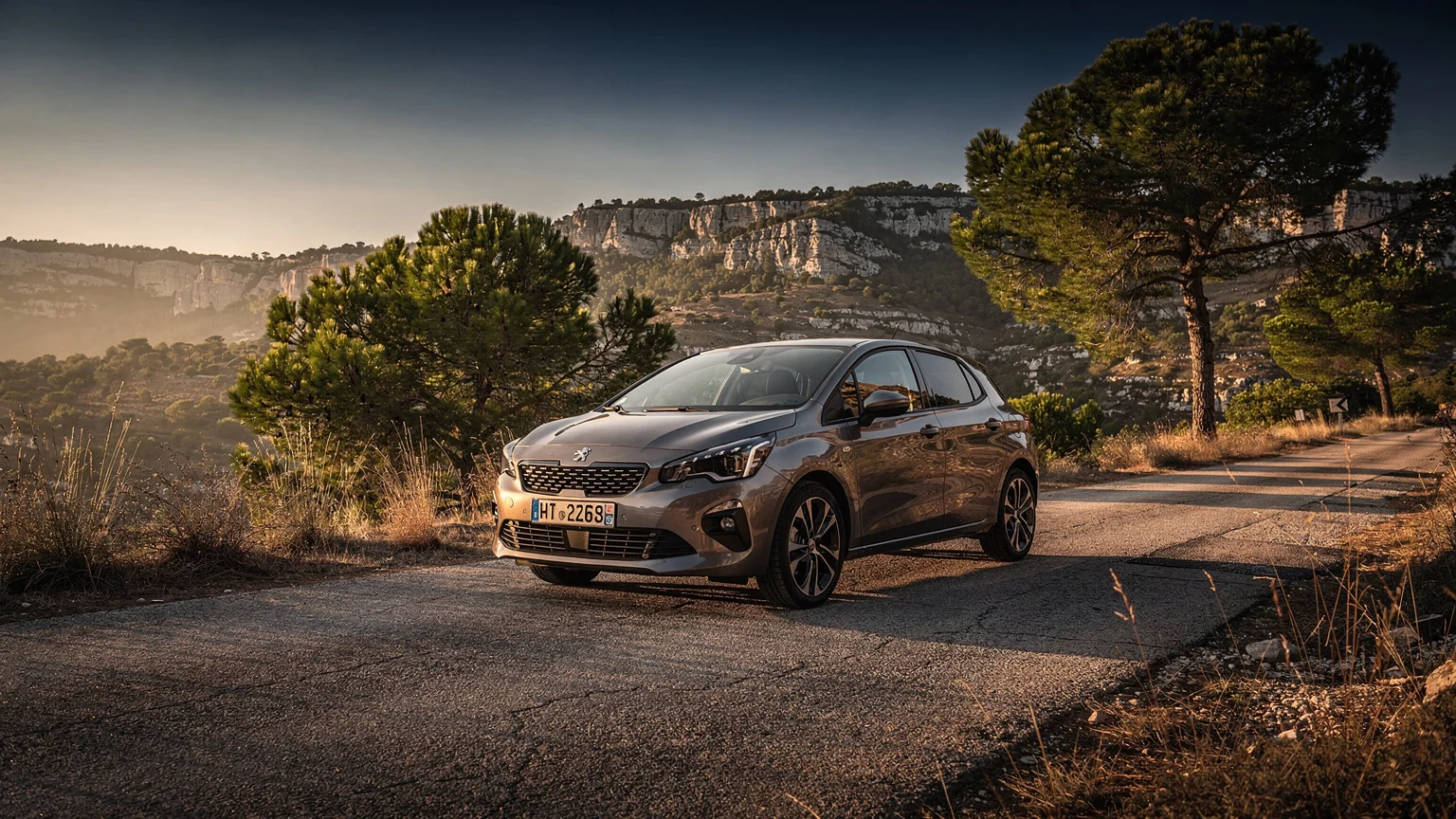 Voiture compacte sur une route de Provence au coucher du soleil